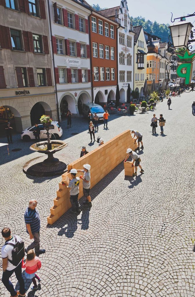 Glaser/Kunz, Wandernde Mauer (2018) in der Feldkircher Marktstraße, Johanniterkirche Feldkirch.