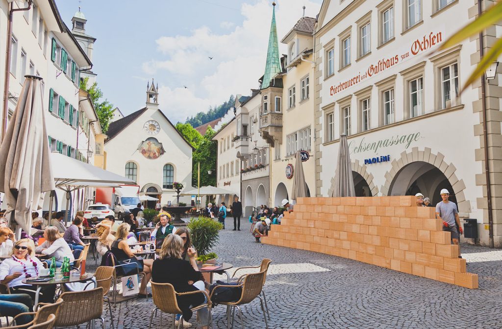 Glaser/Kunz, Wandernde Mauer (2018) in der Feldkircher Marktstraße, Johanniterkirche Feldkirch.